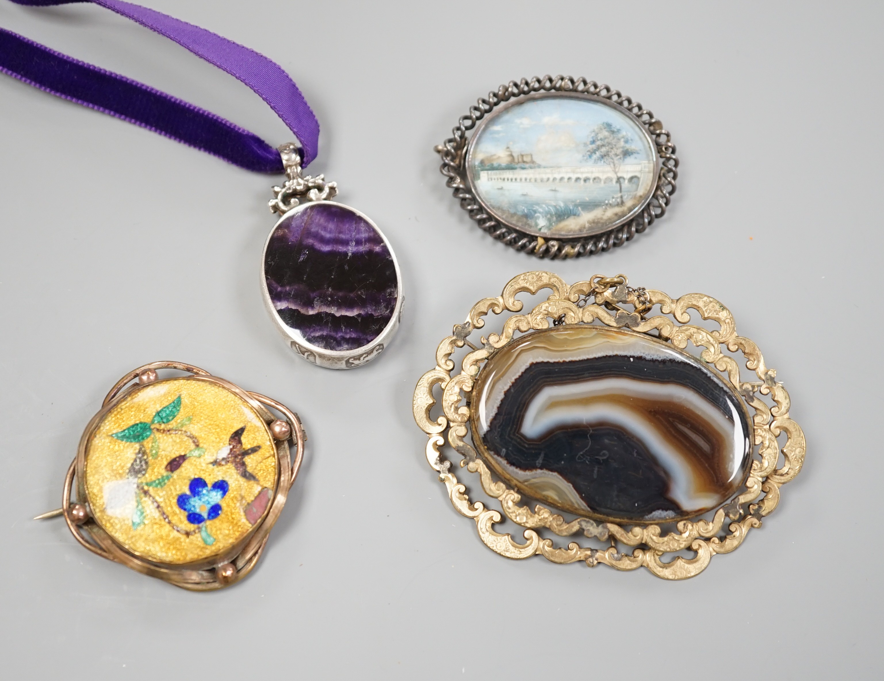 A modern silver mounted bluejohn oval pendant and three other brooches including banded agate.